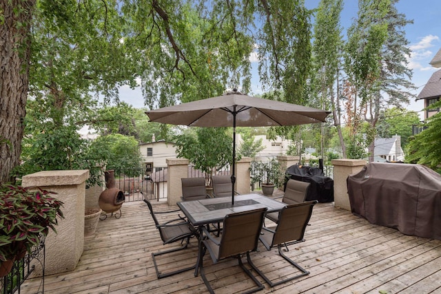 wooden deck with outdoor dining area and a grill