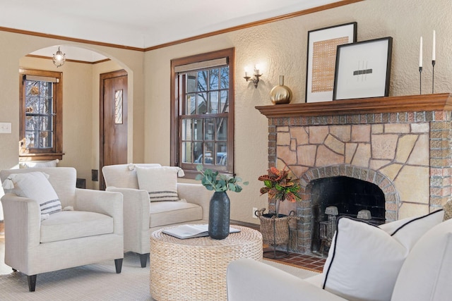 carpeted living room with arched walkways, a healthy amount of sunlight, a fireplace, and a textured wall