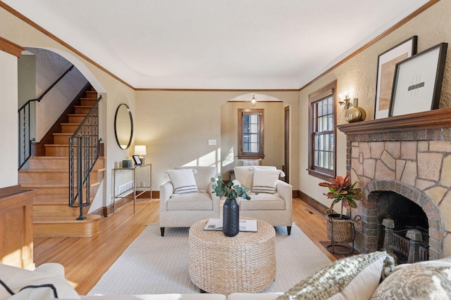 living room with crown molding, baseboards, stairs, wood finished floors, and arched walkways