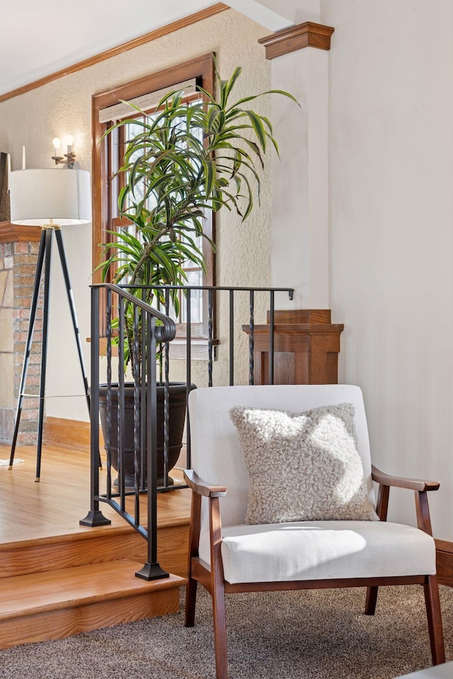 living area featuring plenty of natural light, wood finished floors, and a textured wall