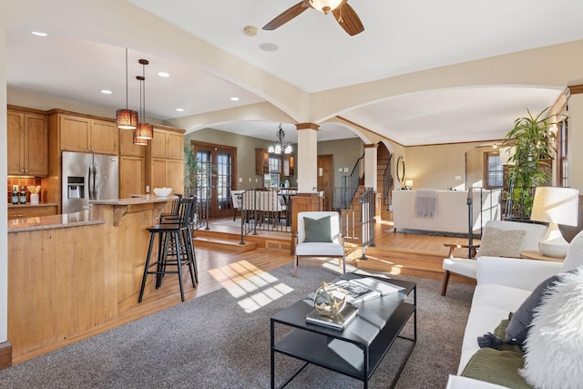 living room featuring ornate columns, recessed lighting, arched walkways, ceiling fan, and light wood-type flooring