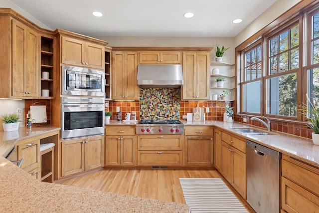 kitchen featuring open shelves, appliances with stainless steel finishes, exhaust hood, and a sink