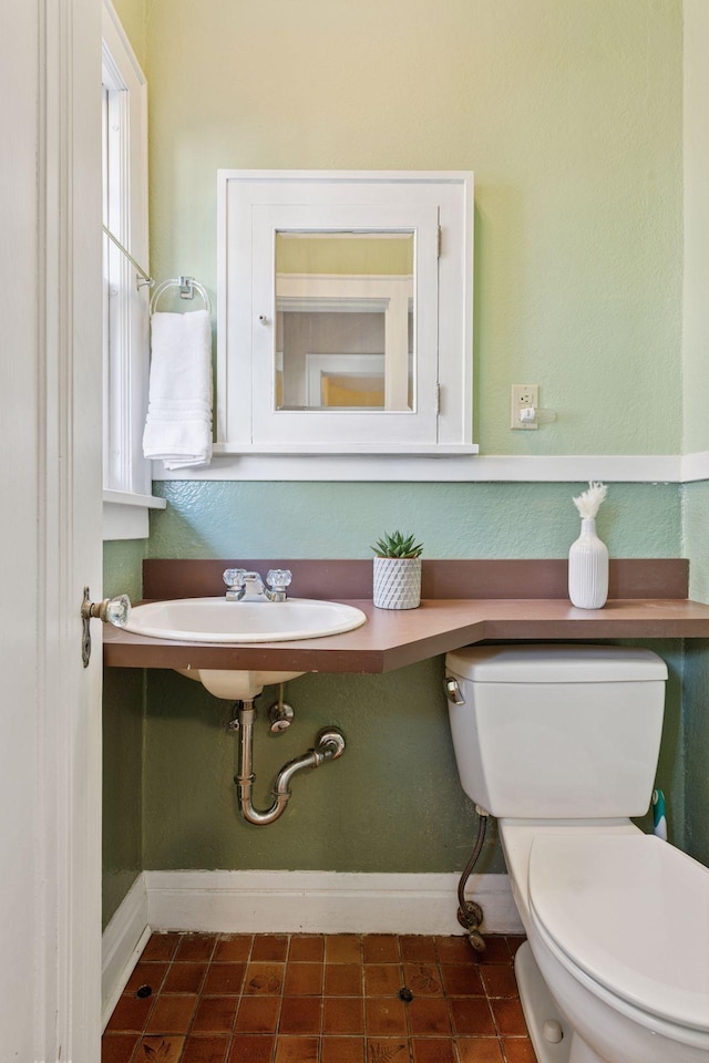 bathroom with toilet and baseboards