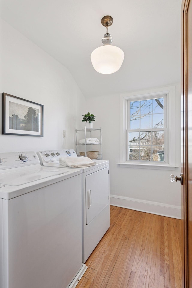 laundry room with laundry area, baseboards, light wood finished floors, and washing machine and clothes dryer