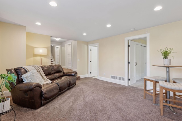 carpeted living area featuring recessed lighting, visible vents, baseboards, and stairs