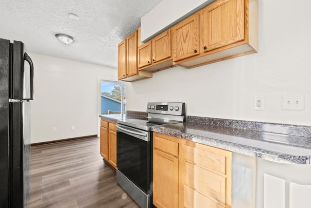 kitchen featuring black refrigerator, dark hardwood / wood-style floors, a textured ceiling, stainless steel electric range oven, and light brown cabinetry