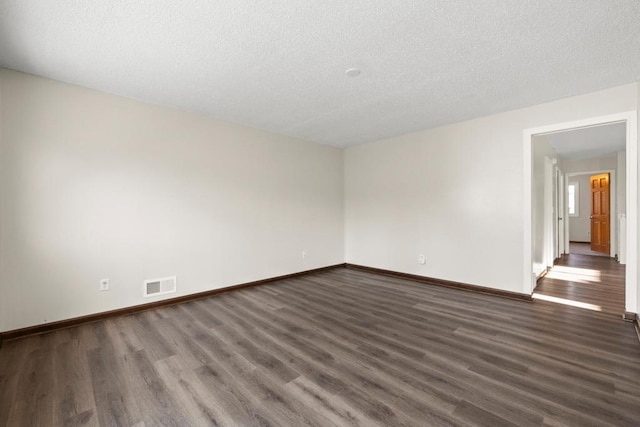 unfurnished room with dark hardwood / wood-style floors and a textured ceiling