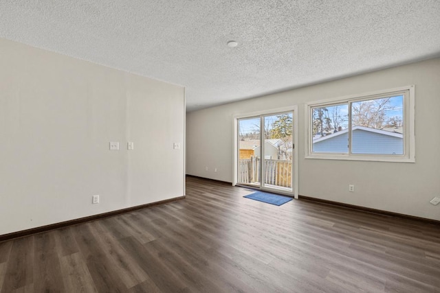 empty room featuring dark hardwood / wood-style floors and a textured ceiling