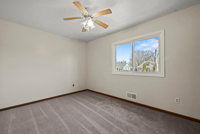 carpeted spare room with ceiling fan and a textured ceiling