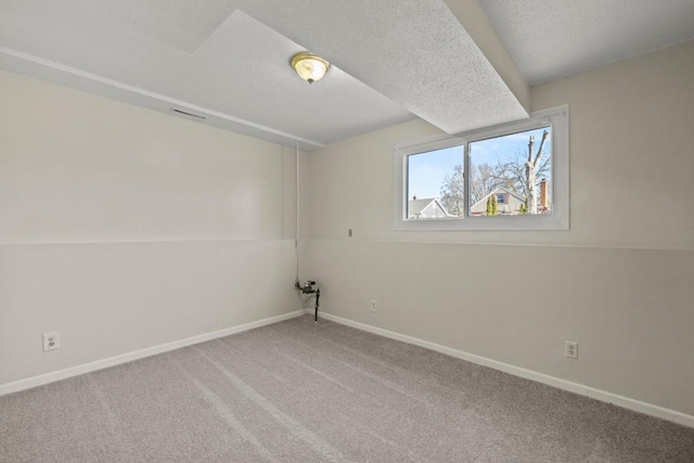 carpeted empty room with a textured ceiling