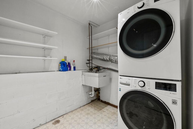 laundry room featuring stacked washer and dryer and sink