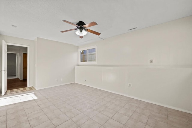 spare room featuring light tile patterned floors and ceiling fan