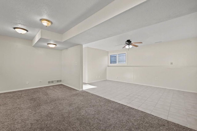 carpeted spare room featuring ceiling fan and a textured ceiling