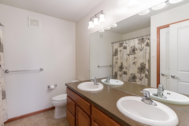 full bath featuring toilet, a textured ceiling, and a sink