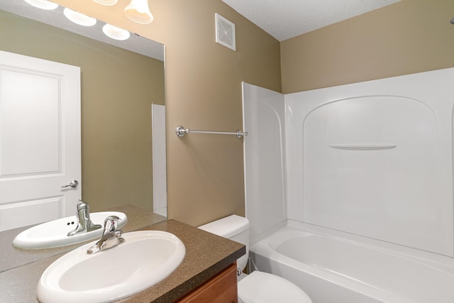 full bathroom with bathing tub / shower combination, visible vents, toilet, vanity, and a textured ceiling