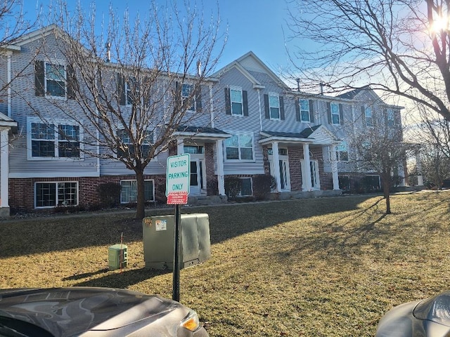 view of front of home with a front yard and brick siding