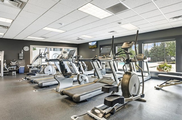 workout area featuring a healthy amount of sunlight, visible vents, and a drop ceiling