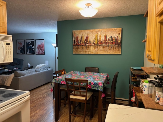 dining space with dark hardwood / wood-style flooring and a textured ceiling