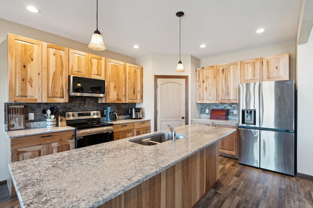 kitchen featuring light brown cabinetry, sink, decorative light fixtures, and stainless steel appliances