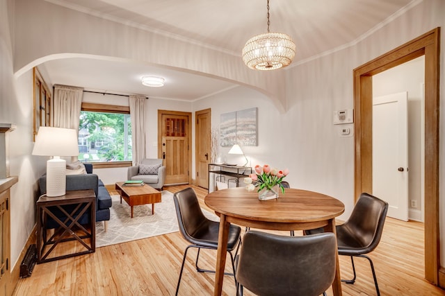 4415 Snelling Ave, Minneapolis, MN 55406 - dining area with arched walkways, light wood-style flooring, a chandelier, and ornamental molding