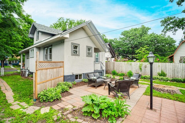 4415 Snelling Ave, Minneapolis, MN 55406 - view of side of property featuring an outdoor hangout area, a patio area, a fenced backyard, and stucco siding