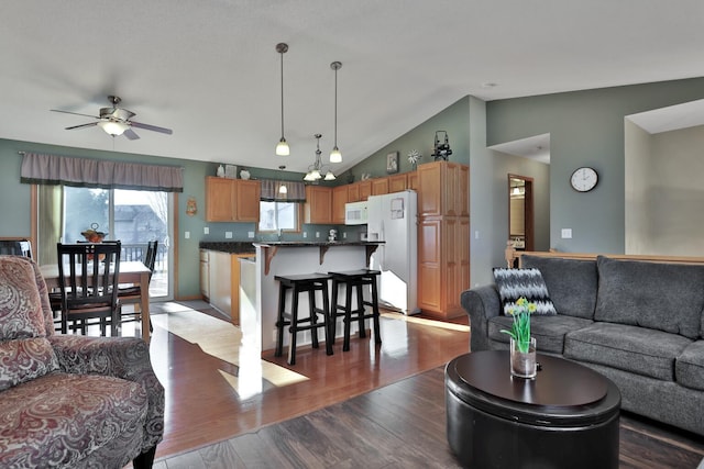 living room featuring hardwood / wood-style flooring, lofted ceiling, and ceiling fan