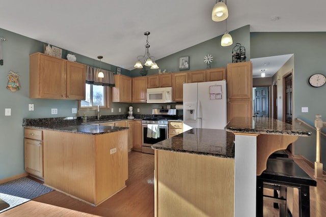 kitchen with white appliances, vaulted ceiling, decorative light fixtures, and a center island