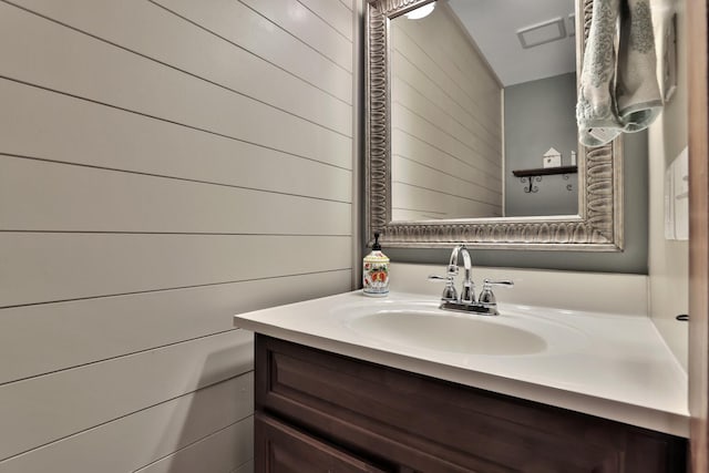 bathroom featuring vanity and wood walls