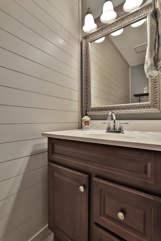 bathroom with vanity and wood walls