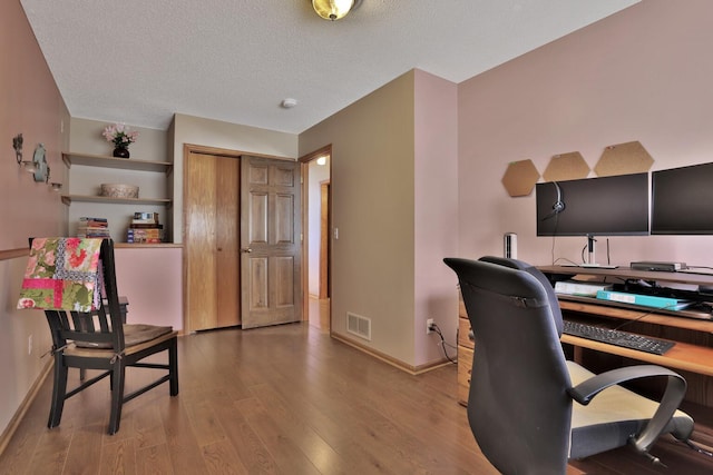 office featuring hardwood / wood-style floors and a textured ceiling