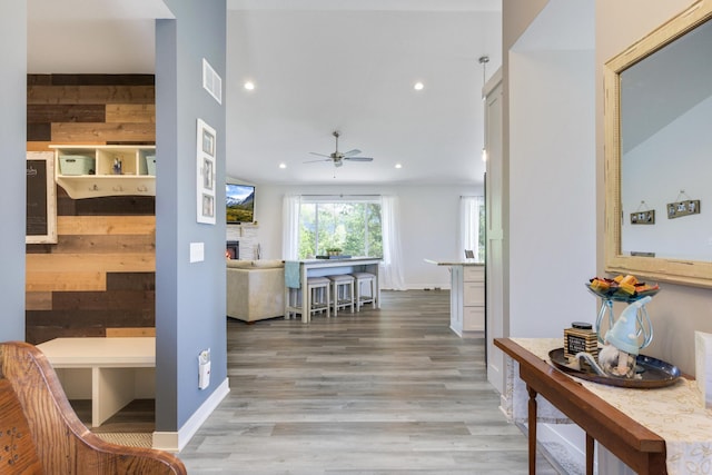 hallway with hardwood / wood-style flooring and wooden walls