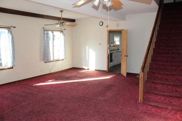 carpeted spare room featuring beam ceiling, a wealth of natural light, and ceiling fan