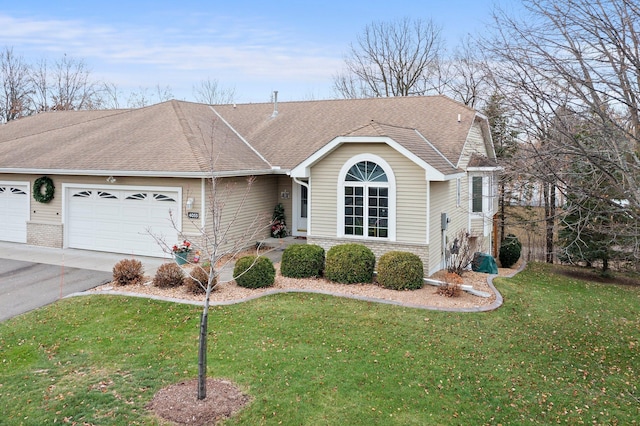 ranch-style home featuring a garage and a front lawn