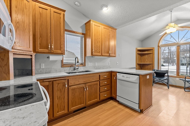 kitchen featuring lofted ceiling, sink, white appliances, kitchen peninsula, and ceiling fan