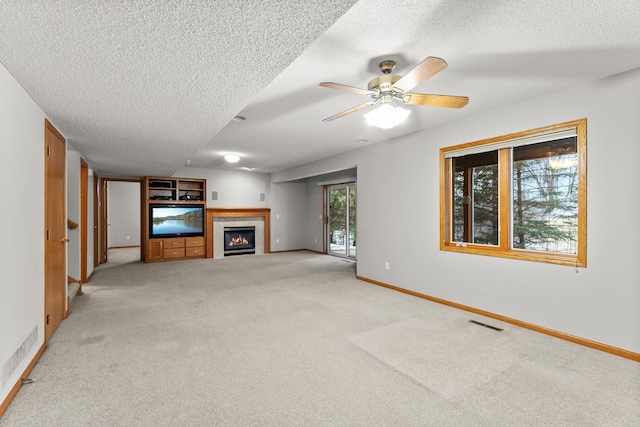 unfurnished living room featuring light carpet, ceiling fan, and a textured ceiling