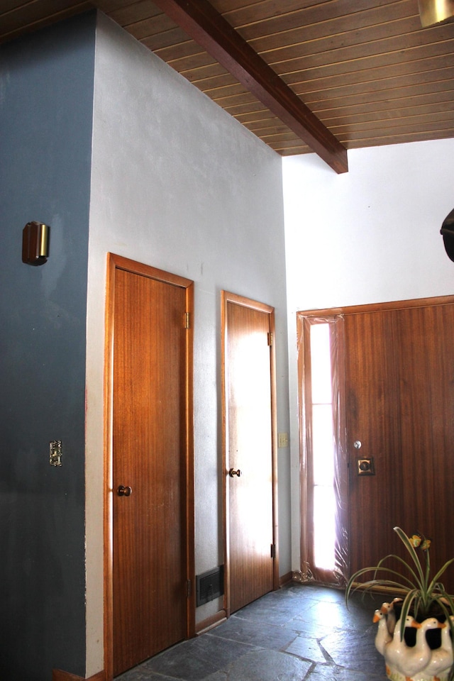 foyer entrance featuring beamed ceiling, a towering ceiling, and wooden ceiling