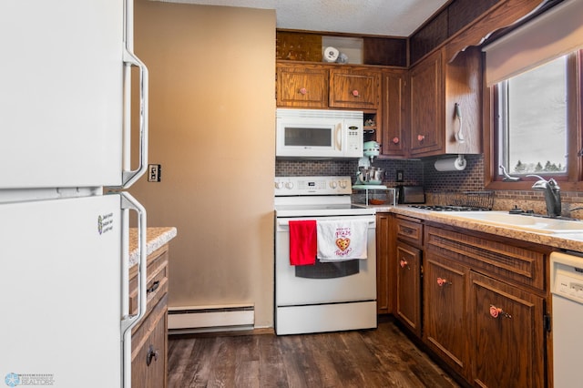 kitchen with sink, white appliances, dark wood-type flooring, baseboard heating, and backsplash