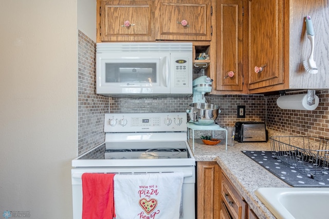 kitchen featuring white appliances and backsplash