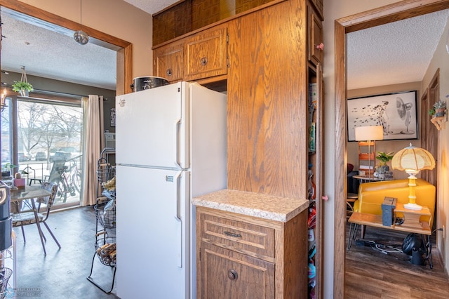 kitchen featuring hardwood / wood-style flooring, white fridge, and a textured ceiling