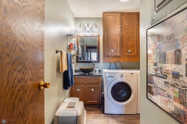 washroom with cabinets, dark hardwood / wood-style floors, sink, and a textured ceiling