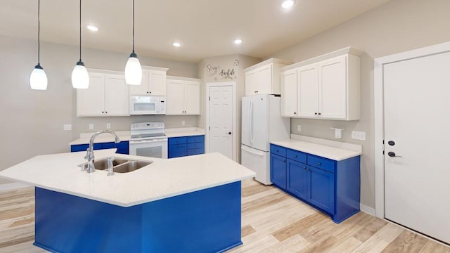 kitchen featuring blue cabinetry, sink, an island with sink, white appliances, and white cabinets