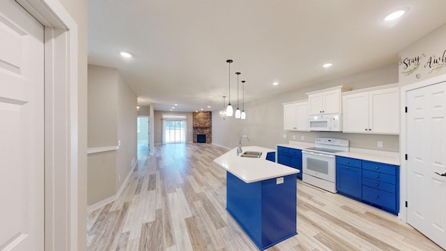 kitchen featuring decorative light fixtures, sink, white cabinets, a center island with sink, and white appliances