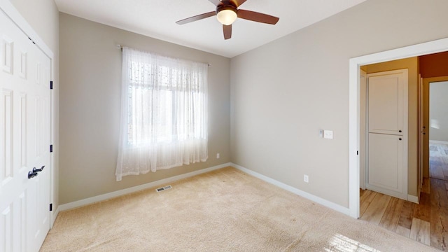 unfurnished bedroom with ceiling fan and light carpet