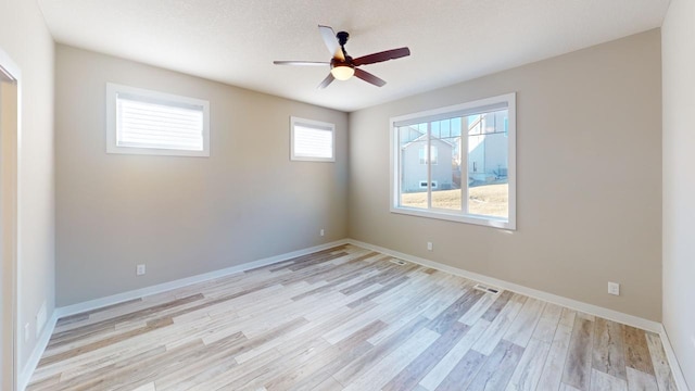 unfurnished room featuring light wood-type flooring, a ceiling fan, and baseboards