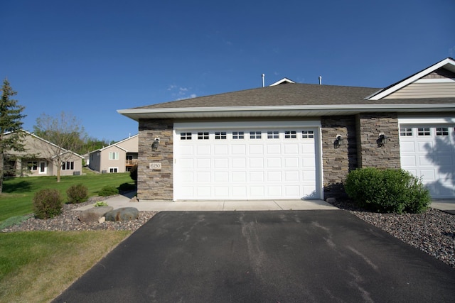 6150 Boulder Ridge Dr, Rockford, MN 55373 - ranch-style house featuring stone siding, driveway, a front lawn, and a shingled roof