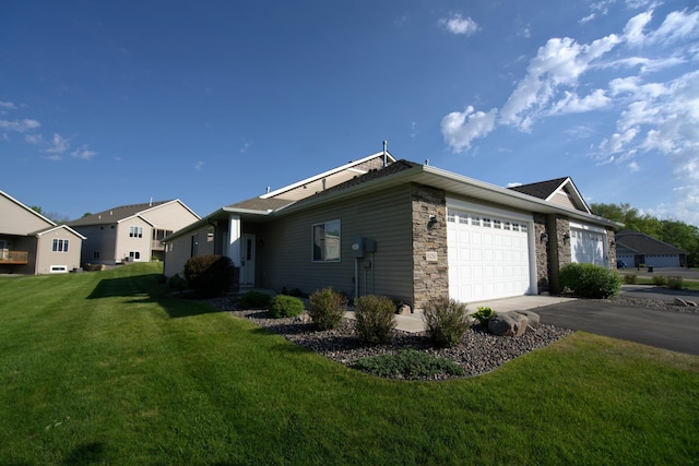 6150 Boulder Ridge Dr, Rockford, MN 55373 - view of property exterior featuring an attached garage, a yard, asphalt driveway, stone siding, and a residential view