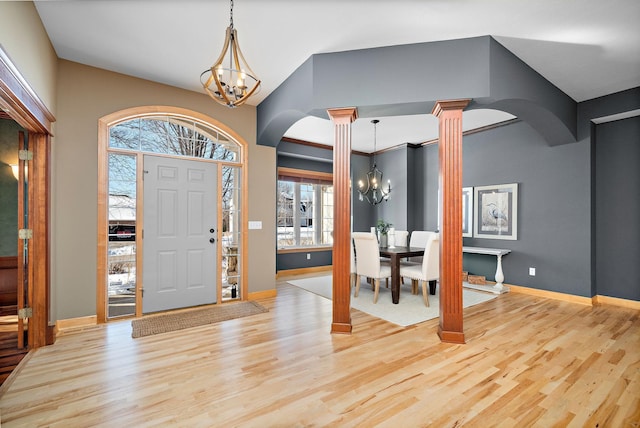 foyer entrance with an inviting chandelier, arched walkways, and ornate columns