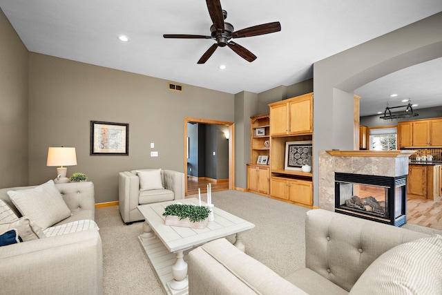 living area with arched walkways, recessed lighting, visible vents, and baseboards