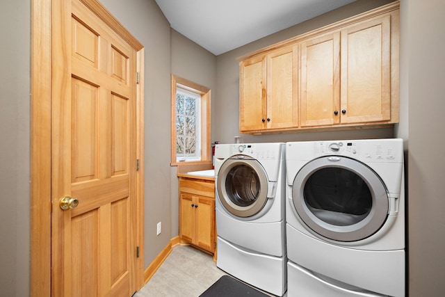 laundry area with baseboards, cabinet space, and washing machine and clothes dryer