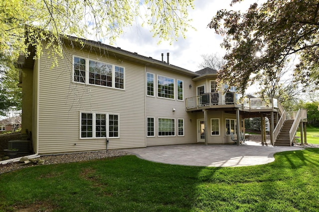 rear view of house featuring a lawn, stairway, a deck, cooling unit, and a patio area